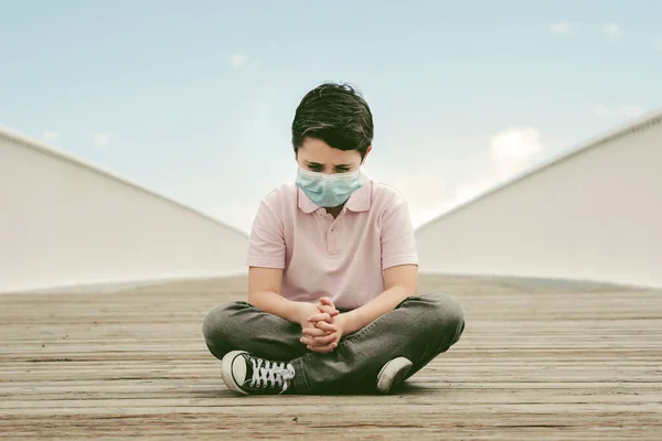 Ledsen Och Omtänksam Unge Bär Medicinsk Mask Sitter Marken — Stockfoto