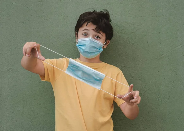 Niño Con Máscara Médica Sosteniendo Una Máscara Médica Protectora Sobre — Foto de Stock