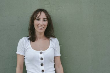 Yeşil arka planda gülümseyen genç kadın