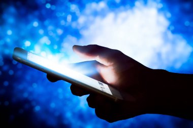 Mavi gökyüzü arkaplanlı akıllı telefonu tutan