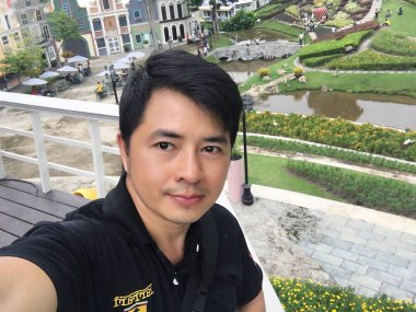 Genç adam parkta selfie çekiyor. 