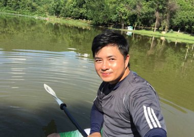 Genç adam nehirde kayak yapıyor. 