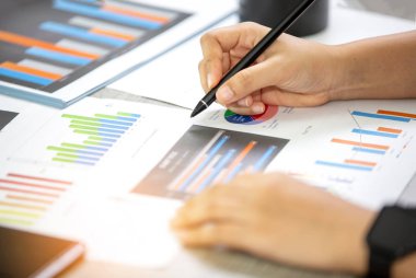 Masa üzerine Grafik Kağıtları ve iş adamları evrak üzerine yazma Yan Görünümü