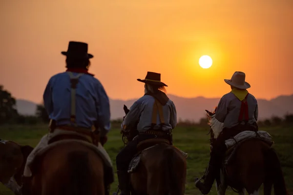 カウボーイと馬の最初の光 川と自然の夕日の光の背景とライフスタイル 銃を持って日没に馬に乗る月 認識されていない人 — ストック写真