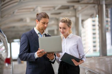 İş arkadaşları şehirde köprüde dururken konuşuyor 