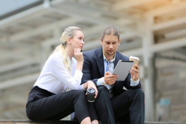 İş arkadaşları şehirde köprüde dururken konuşuyor 