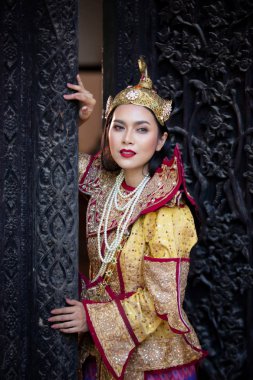 Mandalay Asyalı Bir Kadın Portresi, Altın Geleneksel Giysiler ile Myanmar Woman Ahşap Kapı Oyma Sanat Karşı Duruyor.