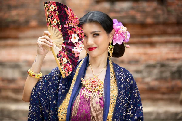 Indonesia Young beautiful woman with Traditional dress standing and look at camera at Gate to heaven Handara Golf Gate in Bedugul, Bali ,Indonesia.