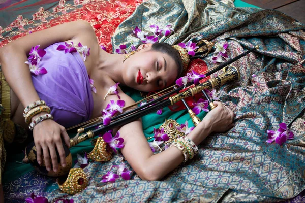 花と楽器で床に横たわる伝統的な衣服の女性のトップビュー — ストック写真