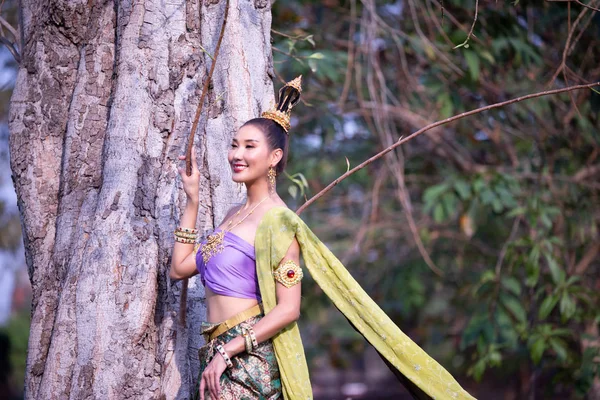 木に立ち向かって遠ざかる伝統衣装の笑顔の女性 — ストック写真