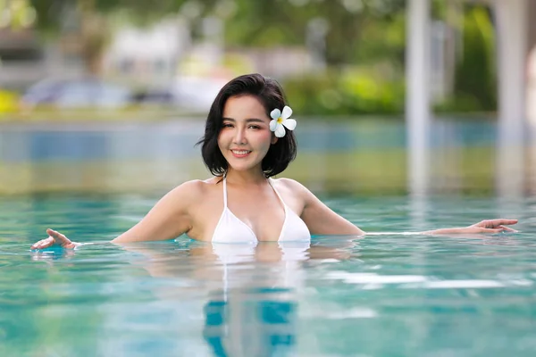 微笑的年轻女子比基尼站在游泳池的肖像 — 图库照片