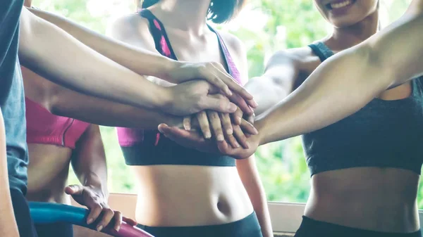 midsection of active people in sportswear hands share together on unity concept