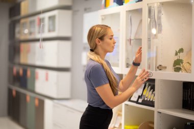 Kitaplıkta bir şey arayan kadınların yan görünüşü