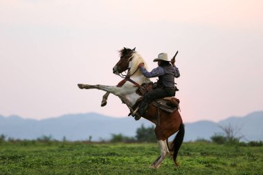 Kovboy ve at ilk ışıkta, doğal ışık arka planı