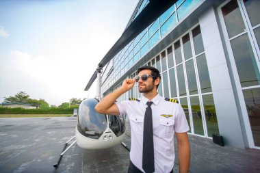 Olgun bir helikopter pilotunun helikopterle seyahat ederken kulaklık kullanırken, iş adamlarının helikopterle seyahat ederken çekilmiş fotoğrafı.