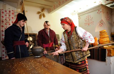 Ukrayna yerlisi kadın ve erkekler kırsal kesimde Noel arifesinde geleneksel tabak kutia hazırlıyorlar.