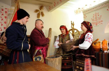 Ukrayna yerlisi kadın ve erkekler kırsal kesimde Noel arifesinde geleneksel tabak kutia hazırlıyorlar.