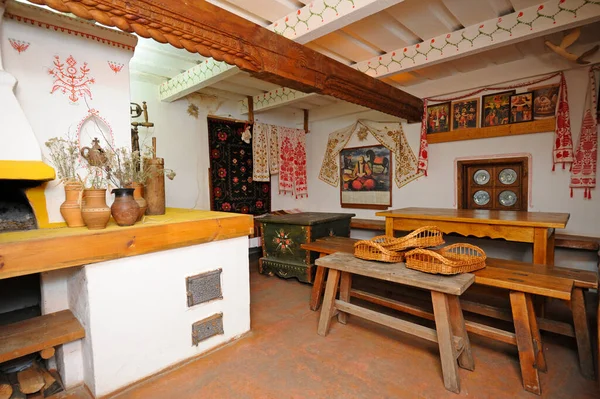 Traditionelle Backöfen, Lehmbänke, Bänke, Tische, Ikonen, die als Teil des Innenraums des ländlichen ukrainischen Haushalts aufgestellt sind — Stockfoto
