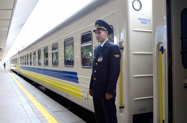 Кондуктор, стоящий у двери вагона пассажирского поезда. 1 октября 2018 года. Центральный вокзал. Остров, Украина
