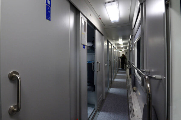 Коридор с дверьми спального вагона первого класса пассажирского поезда
