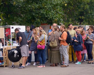 Parkta. İnsanlar bir tezgahın önünde sokak yemeği satarak sırada bekliyor. 3 Haziran 2018. Kiev, Ukrayna