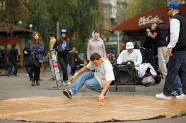 Genç bir adam, sokak dansçısı, kaldırımda dans eden, izleyen insanlar. 21 Mayıs 2012. Kiev Ukrayna