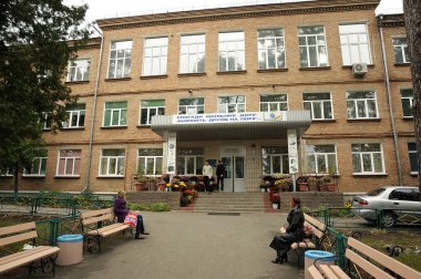 Genç yetimler için Bucha yatılı okulunun ana girişi, banklarda oturan insanlar. 3 Eylül 2017. Bucha, Ukrayna