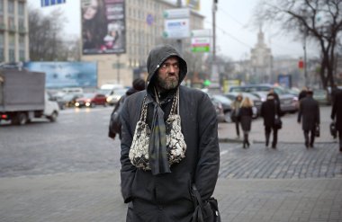 Sokakta yürüyen kirli, yırtık pırtık paltolu yaşlı bir evsiz. 2 Aralık 2018. Kiev, Ukrayna