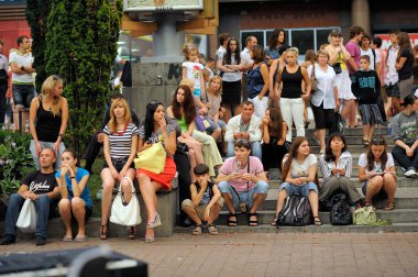 Bir sürü genç insan sokakta basamaklarda oturuyor ve dinleniyor. 23 Temmuz 2013. Kiev, Ukrayna