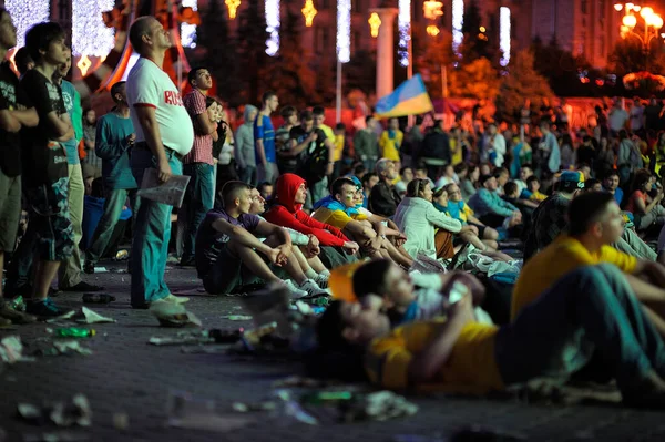 人々は ファンゾーンの舗装の夜にサッカーの試合を見て横に群がって アスファルトの上にゴミ 2012年 2012年7月1日 キエフ ウクライナ — ストック写真