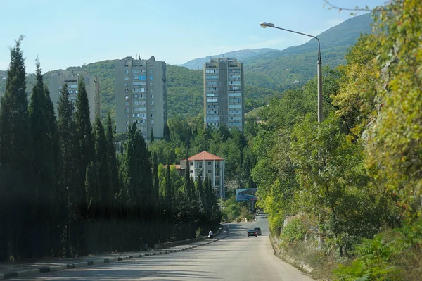 Local road, descent to resort Gurzuf town, mountains on a background