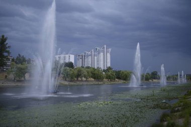 Rusanovka Kanalı manzarası, çalışan çeşmeler, arka plandaki binalar ve bulutlu gökyüzü