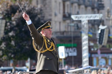 Kondüktör, elinde bir çubuk tutarak bir askeri bandonun müzik çalması için jest yapıyor. Askeri geçit töreni.