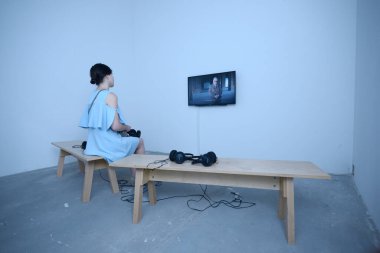 İnteraktif bir odada oturan ve monitörden film izleyen bir kız. Kitap Fuarı Knyzhkovyi Arsenal. 24 Mayıs 2019. Kiev, Ukrayna