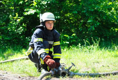 İtfaiyeci yangın sırasında su pompasının vanasını çeviriyor. 5 Haziran 2019. Kievskaya oblast, Ukrayna