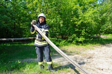 İtfaiyeci yangından sonra hortumu katlıyor. 5 Haziran 2019. 2019. Kievskaya oblast, Ukrayna