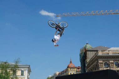Eğlenceli atlayış. Bisikletçi çocuk, mavi gökyüzünde bisikletle yükseliyor. 21 Mayıs 2012. Kiev, Ukrayna