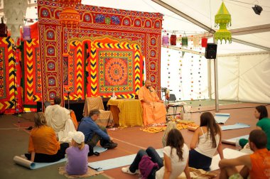 İnsanlar Yoga ve Vedic Kültür Festivali sırasında yerde oturup guru vaazları dinliyor. 19 Ağustos 2012. Kiev, Ukrayna