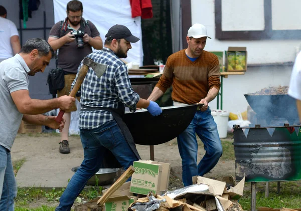 Hareket edebilen bir odun sobasının üzerine koymak için kazan taşıyan adamlar. Ramazan ayı, oruç tutma, oruç tutma. 19 Mayıs 2018. Kiev, Ukrane