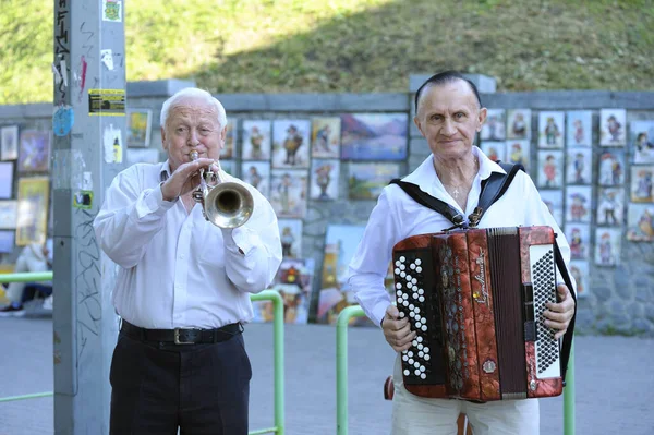 Dos ancianos tocando la trompeta y el acordeón en la calle —  Fotos de Stock