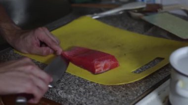 Aşçı mutfakta balık etini bıçakla keser, aşçı yemek hazırlar, balıklı yemekler, diyet yiyecekler.