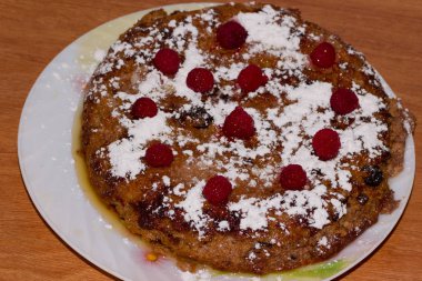 Tabakta ahududu ve kuru üzümlü süzme peynir güveci. Ahşap arkaplan