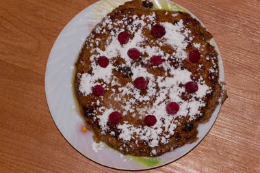 Tabakta ahududu ve kuru üzümlü süzme peynir güveci. Ahşap arkaplan