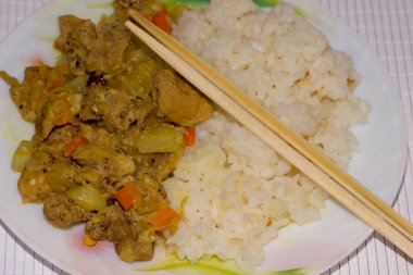 Bambu peçetesinde beyaz bir tabakta pirinçli köri.