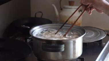 Erişte haşlayan bir kadın.