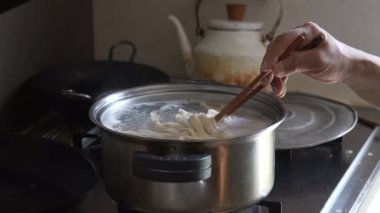 Erişte haşlayan bir kadın.