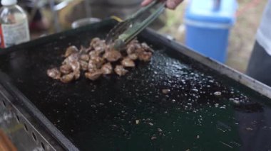 Demir bir tabakta ızgara midyeler.