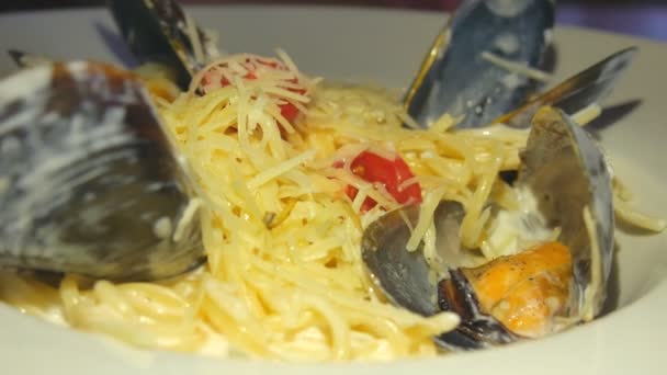 Eten dicht omhoog van Italiaanse pasta carbonara met Parmezaanse kaas en mosselen. — Stockvideo
