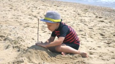 Çocuk oyuncakları ile oynarken ve Kaleler Sahilde bina eğleniyor.