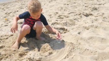 Çocuk oyuncakları ile oynarken ve Kaleler Sahilde bina eğleniyor.